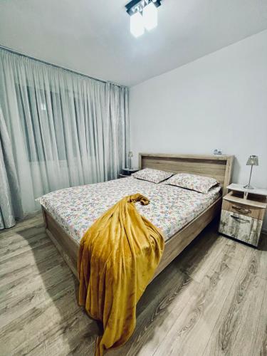 a bedroom with a bed with a blanket on it at GataBagajul Apartments - Vaslui in Vaslui