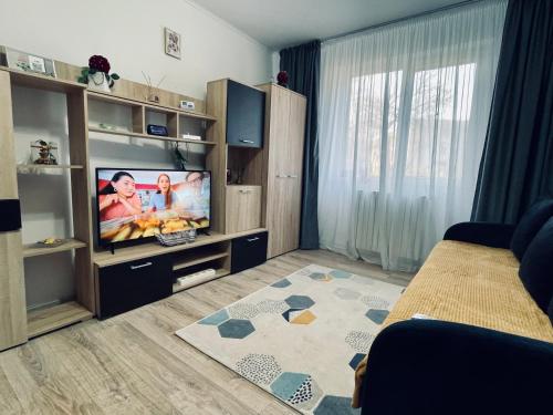 un soggiorno con TV a schermo piatto in una camera di 3S Residence a Vaslui