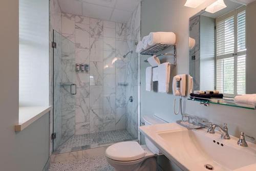 a bathroom with a shower and a toilet and a sink at Nicollet Island Inn in Minneapolis