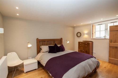 a bedroom with a large bed and a chair at Sunny Brow Barn in Ambleside