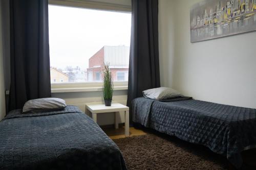 two beds sitting in a room with a window at 4-room apartment. Oulu city center in Oulu