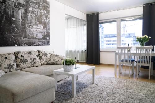 a living room with a couch and a table at 4-room apartment. Oulu city center in Oulu
