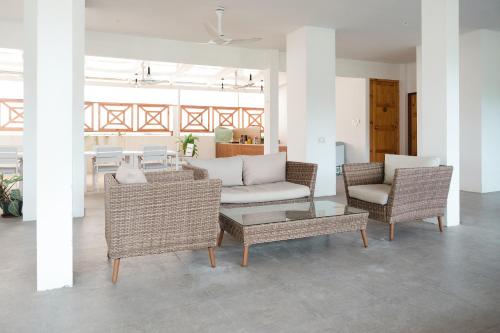 a living room with a couch and chairs and a table at Sunrise by white sand dhigurah in Dhigurah