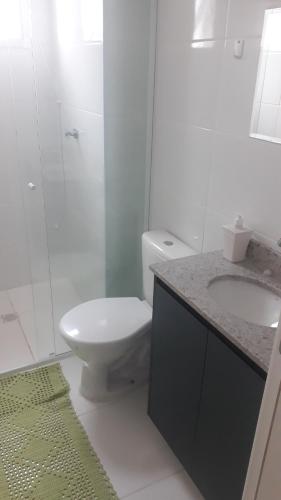 a bathroom with a toilet and a sink and a shower at Residencial Santos Dumont in Mongaguá