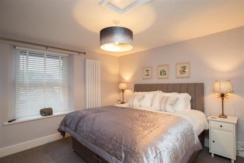 a bedroom with a large bed and a window at Chapel Hill Cottage in Ambleside