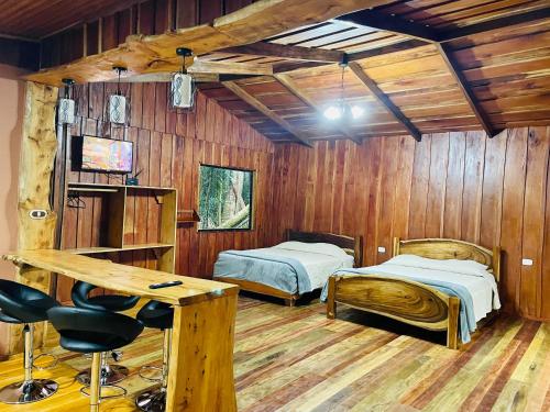 a room with two beds and a desk in it at Cabañas La Montaña Mountain Lodge in Monteverde Costa Rica