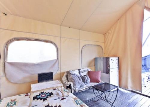 a caravan with a couch and a table in it at H Avenue Hotel Idae Shinchon in Seoul