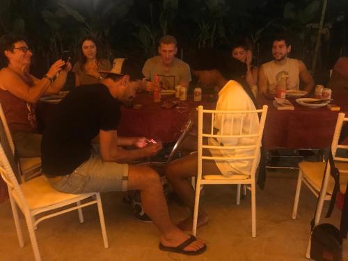 a man and a woman sitting at a table with a group of people at Bee lucky homestay in Cat Ba