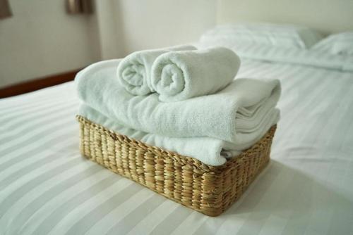 ein Korb mit Handtüchern auf dem Bett in der Unterkunft Bellevue Boutique Bangkok in Amphoe Phra Khanong