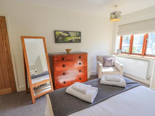 a bedroom with a dresser and a mirror at Croft in Grasmere