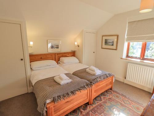 a bedroom with two beds with towels on them at Croft in Grasmere