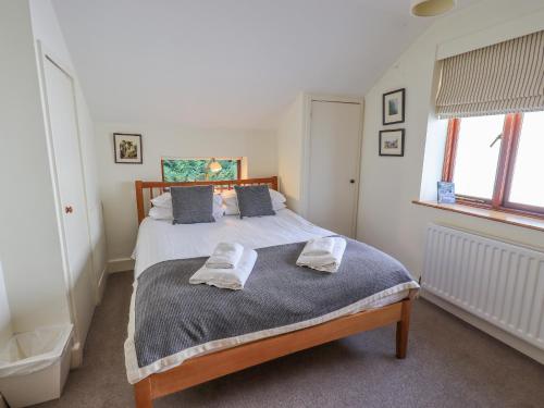 a bedroom with a bed with two towels on it at Croft in Grasmere