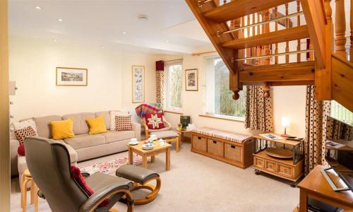 a living room with a couch and a staircase at Lingmoor View in Ambleside