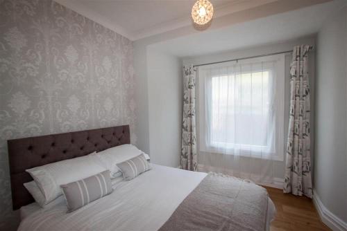 a bedroom with a white bed and a window at Waterside in Ambleside