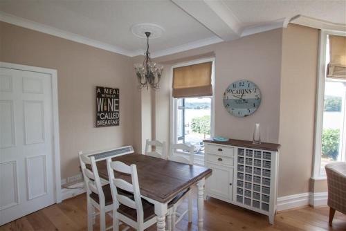 a dining room with a table and chairs and a clock at Waterside in Ambleside