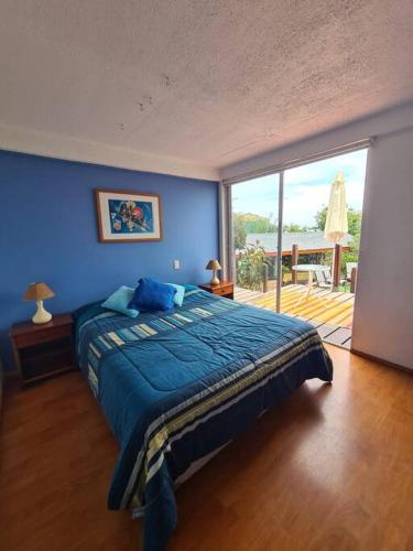 Dormitorio azul con cama y ventana grande en Gran casa en Totoralillo con vista al mar y más! en Coquimbo