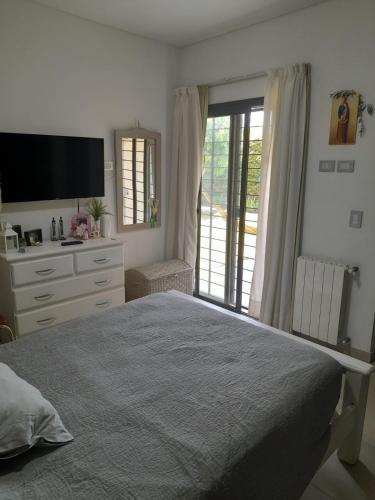 1 dormitorio con 1 cama, vestidor y TV en excelente casa con pileta en Luján de Cuyo