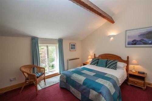a bedroom with a large bed and a window at Grisedale Cottage in Keswick