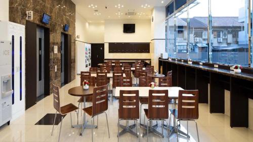 a restaurant with tables and chairs in a room at Toyoko Inn Tokyo Akishima-eki Minami-guchi in Akishima