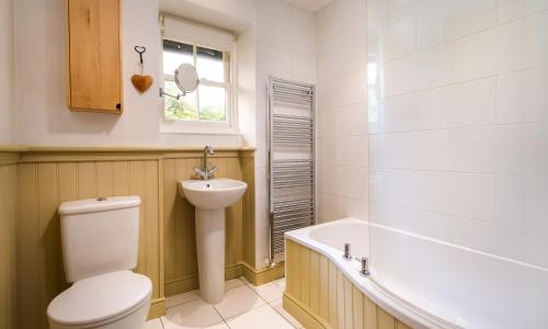 a bathroom with a toilet and a sink and a tub at Greystones in Bowness-on-Windermere
