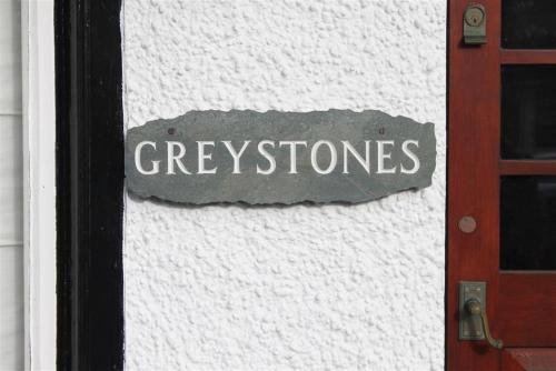 a sign on the side of a door with the wordozygoses at Greystones in Bowness-on-Windermere