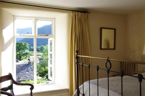 um quarto com uma cama e uma grande janela em Thomas Grove House em Penrith