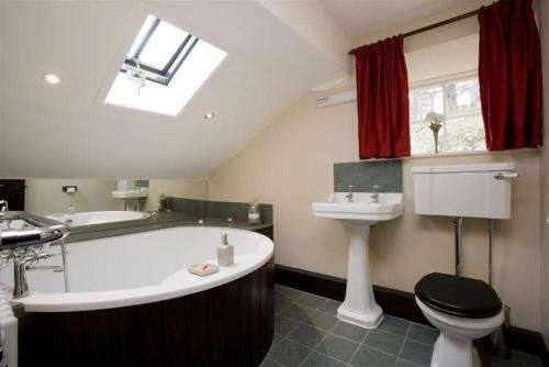 a bathroom with a tub and a toilet and a sink at Yew Tree Farm in Coniston