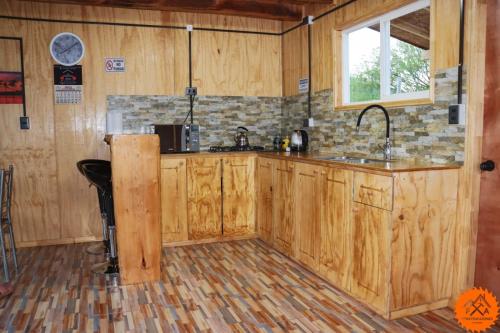 - une cuisine avec des placards en bois et un évier dans l'établissement Cabaña Río Noroeste, à Futaleufú