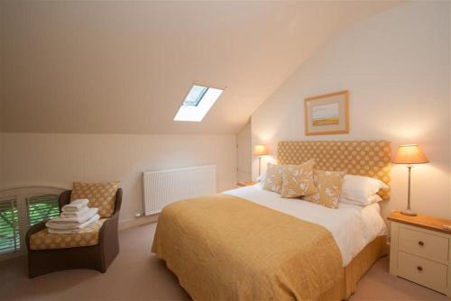 a bedroom with a bed and a chair and a window at The School in Keswick