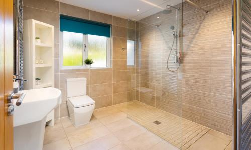 a bathroom with a shower and a toilet and a sink at Glebe Holme in Windermere