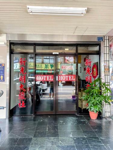 un hotel con puertas de cristal en un edificio en New Bright Hotel en Zhunan