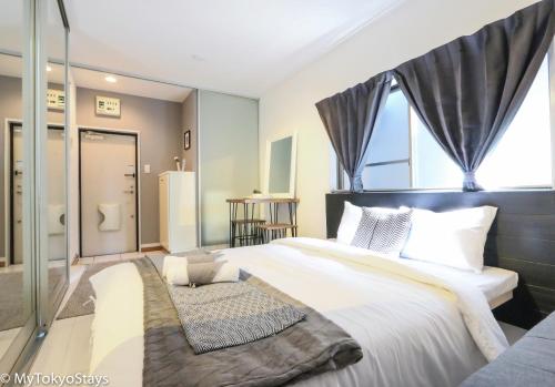 a bedroom with a large bed and a bathroom at NEW!Shibuya Prime Unit, near Shibuya Sky & Hachiko in Tokyo