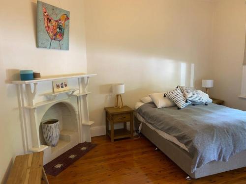 a bedroom with a bed and a fireplace at Central CBD House in Wagga Wagga