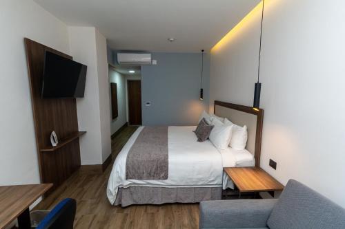 a hotel room with a bed and a couch at Hoteles Piedra Alta by De Los Perez in San Andrés Tuxtla