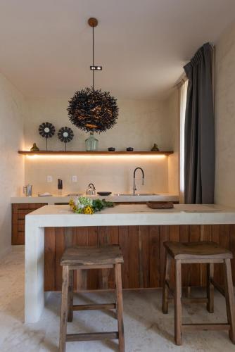 a kitchen with a sink and a counter with two stools at Unho Tulum in Tulum