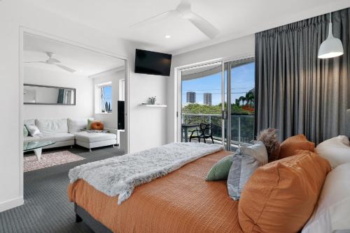 ein Schlafzimmer mit einem großen Bett und ein Wohnzimmer in der Unterkunft Chevron Sails in Gold Coast