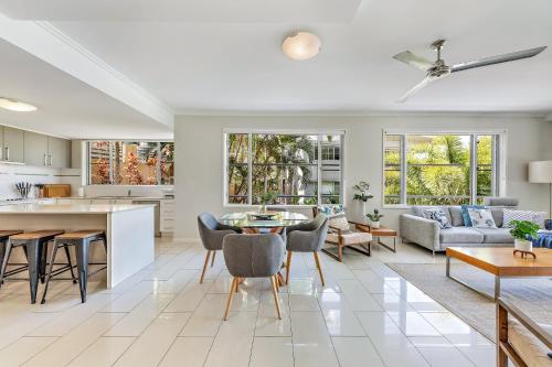 eine Küche und ein Wohnzimmer mit einem Tisch und Stühlen in der Unterkunft Airlie Summit Apartments in Airlie Beach