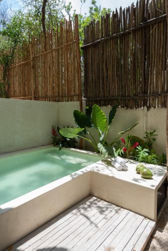 a swimming pool in a backyard with a wooden fence at Unho Tulum in Tulum