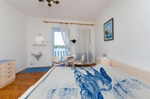 ein Schlafzimmer mit einem Bett mit einer blauen Decke darauf in der Unterkunft Rooms Sonja P in Rab