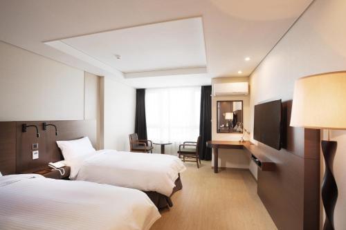 Ένα ή περισσότερα κρεβάτια σε δωμάτιο στο Crown Harbor Hotel Busan
