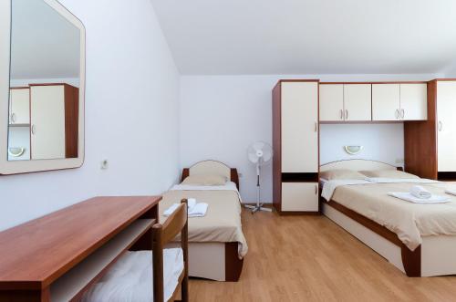 een kamer met 2 bedden en een spiegel bij Apartments Marija P Lopar in Lopar