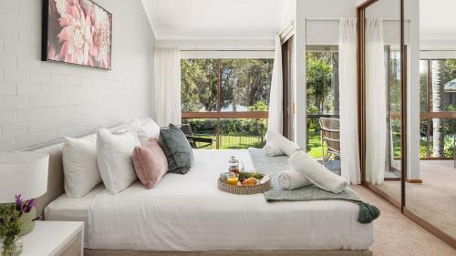 a living room with a white couch with a basket of fruit on it at Sunset at The Moorings in Soldiers Point