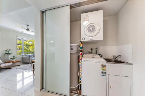 a kitchen with a washer and dryer at Airlie Summit Apartments in Airlie Beach