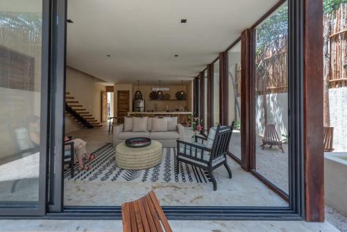 a living room with large glass windows and a couch at Unho Tulum in Tulum