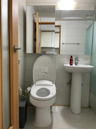 La petite salle de bains est pourvue de toilettes et d'un lavabo. dans l'établissement Hongdae Residence-4 - 1min from Hongik Univ Station #1, à Séoul