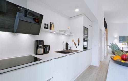 a white kitchen with a sink and a bowl of fruit at Nice Home In Lembruchdümmer See in Lembruch