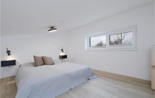 a white bedroom with a bed and a window at Nice Home In Lembruchdümmer See in Lembruch