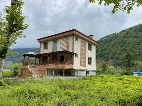 a house sitting on top of a green hill at Zeni Villa - Fırtına Deresinde mükemmel konaklama in Rize