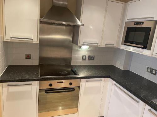 a kitchen with white cabinets and a stainless steel stove at High vibes home in Chelmsford