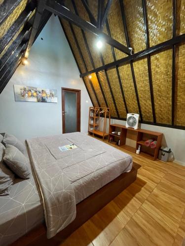 a bedroom with a large bed and a wooden floor at Oemah Batur in Kintamani